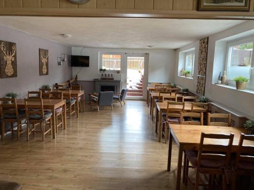 une salle à manger avec des tables et des chaises en bois dans l'établissement Pension AdlerHorst, à Steindorf am Ossiacher See