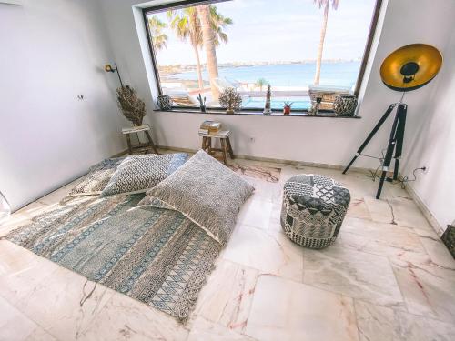 a bedroom with a view of the beach from a window at Villa Los Flamencos by Veaco- Beachfront & pool in Corralejo