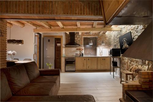 a living room with a couch and a kitchen at Masovería l'Era in Arbúcies