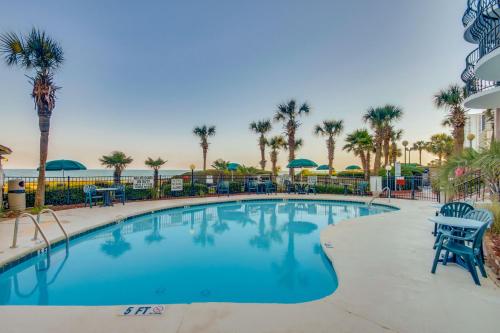 a swimming pool at a resort with palm trees at Hosteeva 17th Floor Palms Resort Penthouse Oceanfront w Balcony in Myrtle Beach