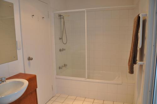 y baño con ducha, bañera y lavamanos. en Kangaroo Pause Holiday home at Clayton Bay, en Clayton Bay
