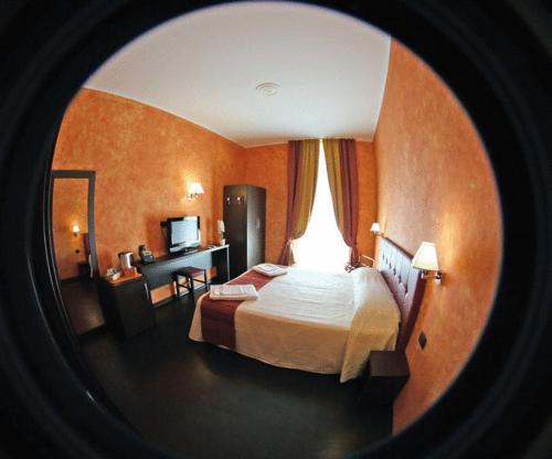 a hotel room with a large bed and a desk at Pisolo Resort in Sanremo