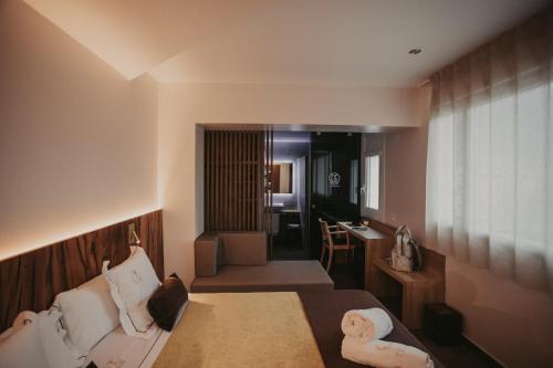 リポイにあるLa Trobada Hotel Boutiqueのベッドとデスクが備わるホテルルームです。