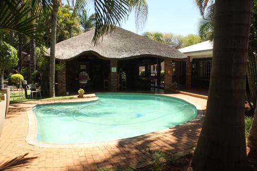 a swimming pool in front of a house at Ngwenya Boutique Hotel in Lephalale