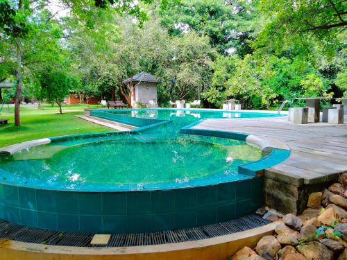 a large pool with a hot tub in a yard at Nil Diya Mankada Safari Lodge in Udawalawe