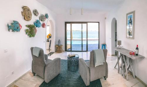 a living room with chairs and a view of the ocean at Villa Los Flamencos by Veaco- Beachfront & pool in Corralejo