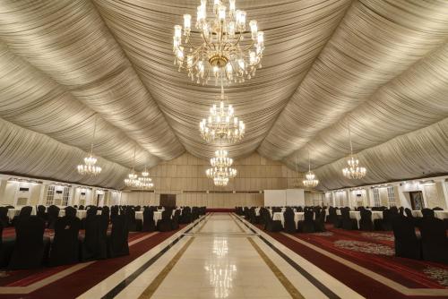 a large banquet hall with chandeliers and chairs at Pearl Continental Hotel, Karachi in Karachi