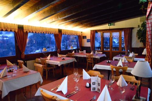 a dining room with tables and chairs and windows at Auberge la Tzoumaz in La Tzoumaz