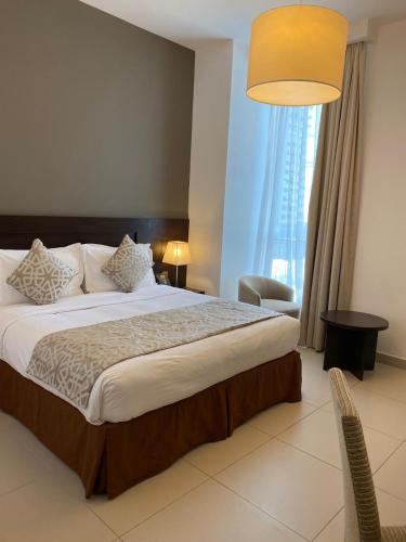 a bedroom with a large bed with a large window at Ascott Rafal Olaya Riyadh in Riyadh