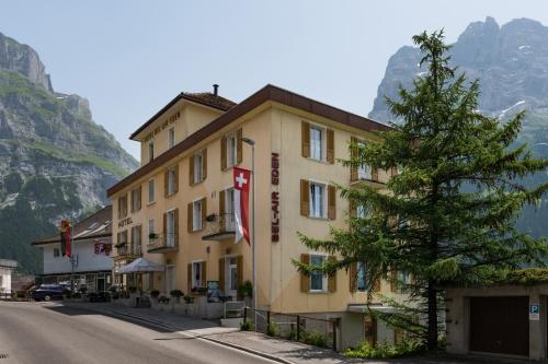 a hotel with a tree in front of a mountain at Bel-Air Eden in Grindelwald