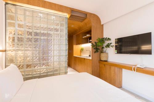 a bedroom with a large window and a television at CityHouse - CityOasis in Ho Chi Minh City