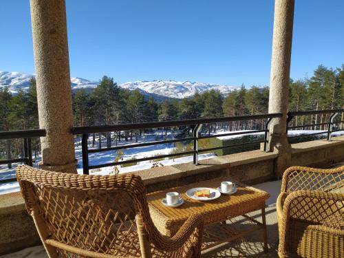 a table and chairs on a balcony with mountains at Parador de Gredos in Navarredonda de Gredos