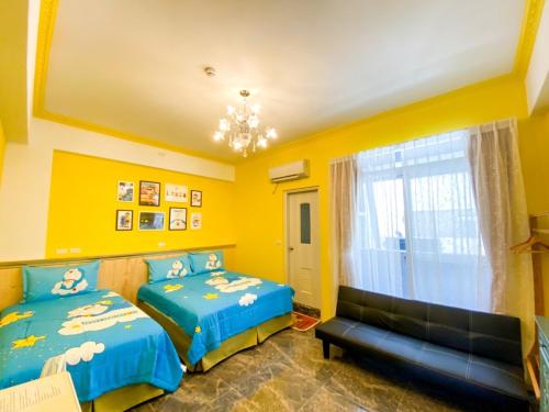 two beds in a room with yellow walls at 15電梯民宿 in Taitung City