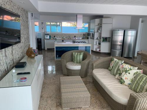a living room with two couches and a kitchen at Mansão beira Mar em Geriba Búzios in Búzios