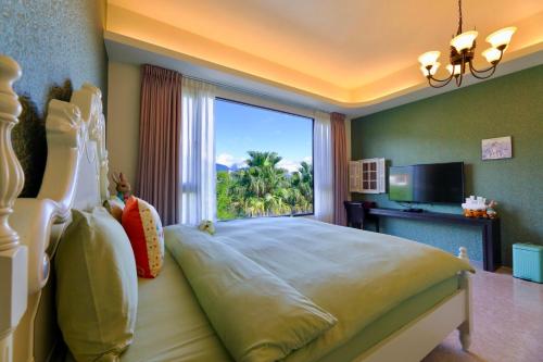 sypialnia z dużym łóżkiem i dużym oknem w obiekcie Floral Land B&B w mieście Zhixue
