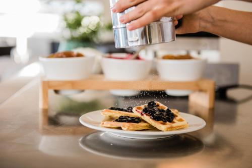 a person is making food on a plate on a counter at Hotel Giulia in Lido di Camaiore