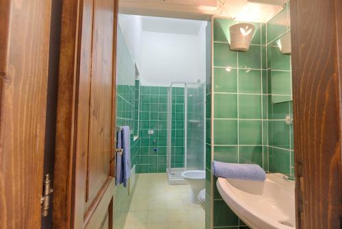 a green bathroom with a sink and a toilet at Residence Oasi e Oasi Blu in San Teodoro