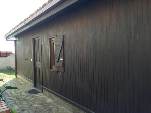a brown building with a door and a window at Bungalow 3 (adosado) - Playa Arnela in Carballo