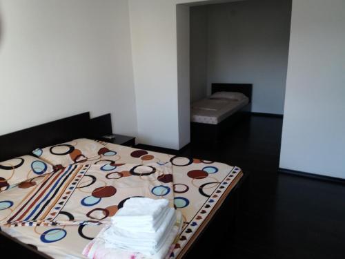 een kleine slaapkamer met een bed met een kleurrijke deken bij Apartament Kamino in Mamaia Nord – Năvodari