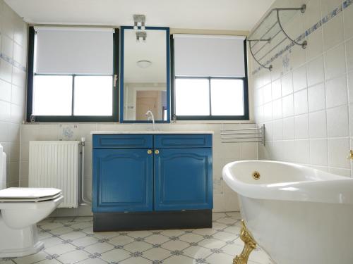 カラントスウオーフにあるBuitenplaats 150 Callantsoogのバスルーム(バスタブ、トイレ付)の青いキャビネット