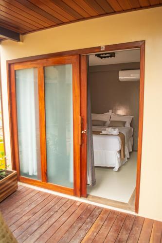 a sliding glass door leading to a bedroom with a bed at Haka Maori Jericoacoara in Jericoacoara