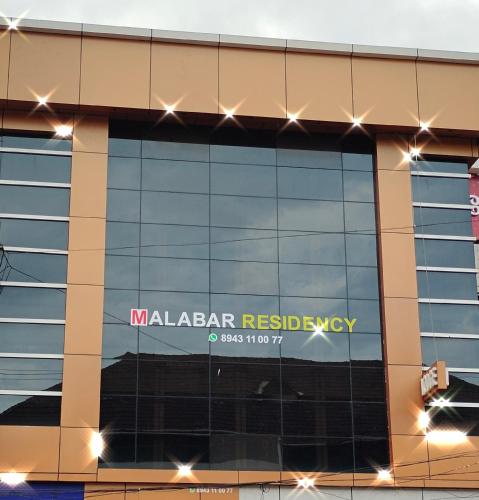 a building with a sign on the side of it at MALABAR Residency in Perintalmanna