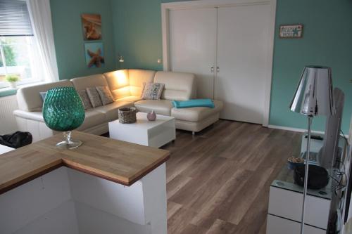 ein Wohnzimmer mit einem Sofa und einem Tisch in der Unterkunft Das Weiße Haus Am Meer in Eckernförde
