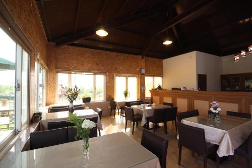 a dining room with tables and chairs and windows at Countryside B&B in Ruisui