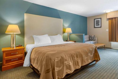 a hotel room with a large bed and a couch at Quality Inn & Suites Apex-Holly Springs in Apex