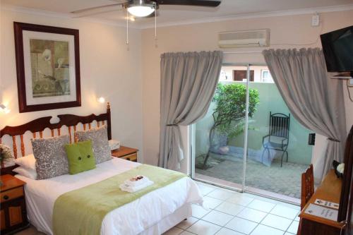 a bedroom with a bed and a sliding glass door at Ngwenya Boutique Hotel in Lephalale