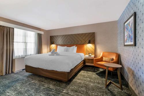 ナシュアにあるClarion Innの大きなベッドと椅子が備わるホテルルームです。