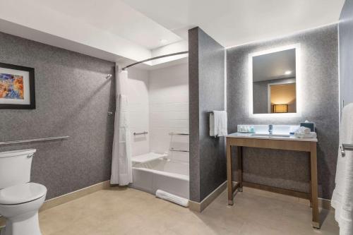 a bathroom with a toilet and a sink at Clarion Inn in Nashua