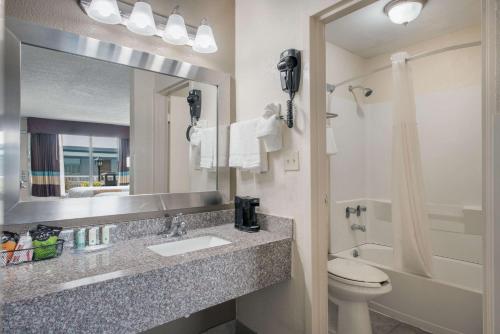 a bathroom with a sink and a toilet and a mirror at Quality Inn Concord Kannapolis in Concord