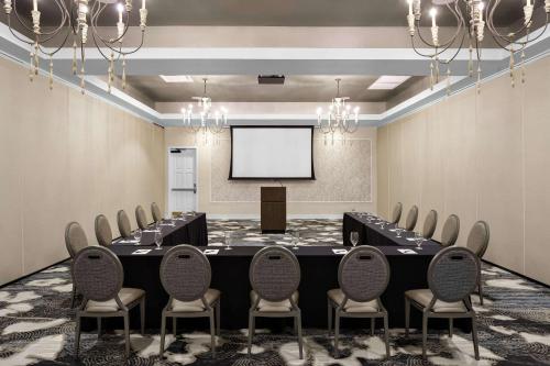 a conference room with a table and chairs and a screen at Beaufort Hotel in Beaufort