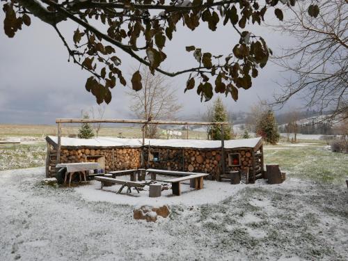 a log cabin with a picnic table in the snow at Apartment at Sedliacky Dvor - Brezno in Brezno