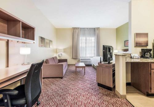 a hotel room with a couch and a tv at Birch Hills Suites - Blue Ash in Blue Ash
