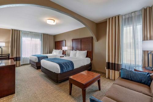 a hotel room with two beds and a couch at Comfort Inn & Suites Ventura Beach in Ventura