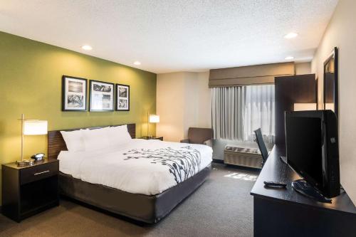 a hotel room with a bed and a television at Sleep Inn & Suites Niantic North in Niantic