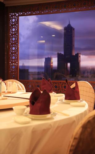 a table with red napkins on top of a white table with a city skyline at Han Hsien International Hotel in Kaohsiung