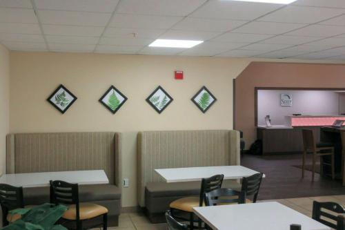 een wachtkamer met stoelen en tafels en een muur bij Sleep Inn & Suites Ft Lauderdale International Airport in Dania Beach