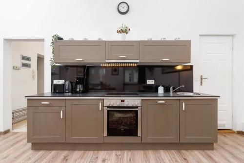 een keuken met bruine kasten en een fornuis met oven bij Apartment Pijarska Kraków by Renters in Krakau