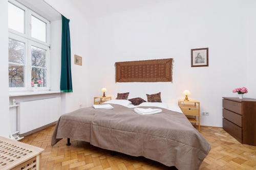 een slaapkamer met een groot bed en 2 ramen bij Apartment Pijarska Kraków by Renters in Krakau
