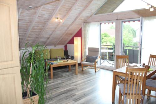 a living room with a wooden ceiling and a table at Ferienwohnungen Lohner Höhe in Bad Sassendorf