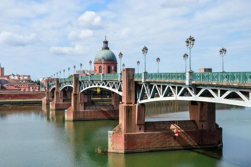 a bridge over a river with a domed building at Kyriad Toulouse Blagnac Aéroport in Blagnac