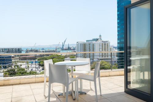 stół i krzesła na balkonie z widokiem w obiekcie Dockside Apartments w Kapsztadzie
