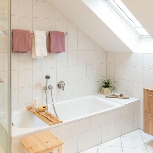 a bathroom with a bath tub in a attic at Ferienwohnungen Lohner Höhe in Bad Sassendorf