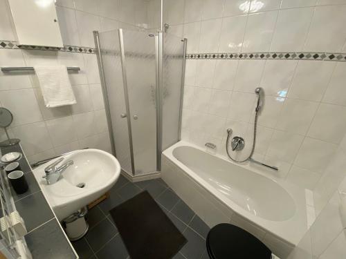 ein Badezimmer mit einem Waschbecken, einer Dusche, einer Badewanne und einem WC in der Unterkunft Ferienwohnung am Burgberg in Marquartstein