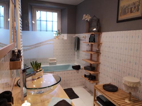 a bathroom with a tub and a glass table at Manoir de l'Alleu in La Chapelle-Chaussée