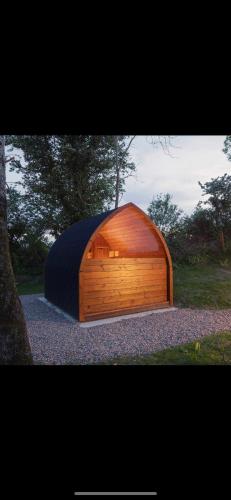 a large wooden building with a black cover at Oakwell holiday village in Ramelton