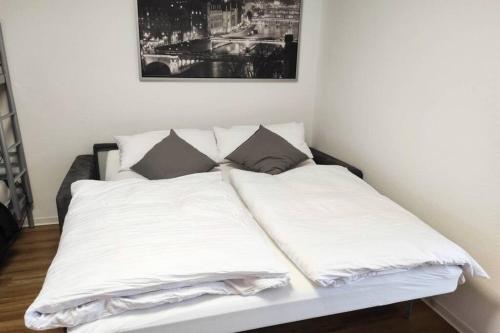 Bett mit weißer Bettwäsche und Kissen in einem Zimmer in der Unterkunft Zentrum Speyer Premium-Apartment in Speyer